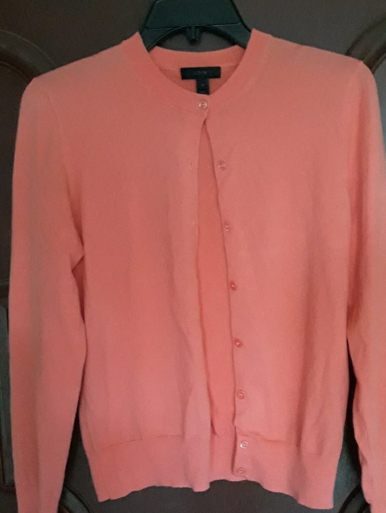 An orange JCrew sweater black label cardigan